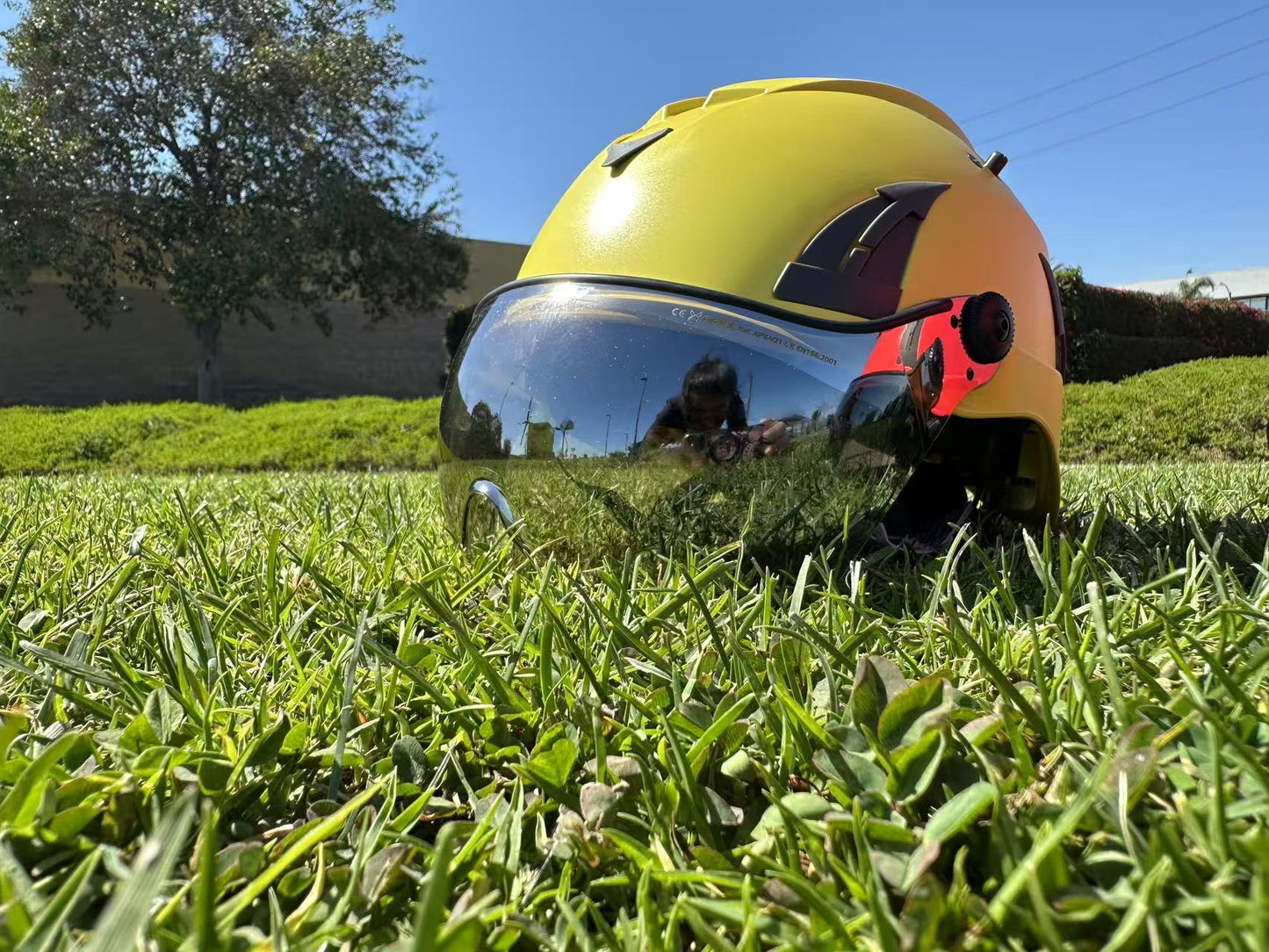 Low angle of yellow AeroPro Safety Helmets with Smoke Visor Kit on Grass. ANSI/ISEA Z89.1-2014 Type 1 Class C Safety Helmet with Smoke Visor used for Construction, Rescue & Arborist. 