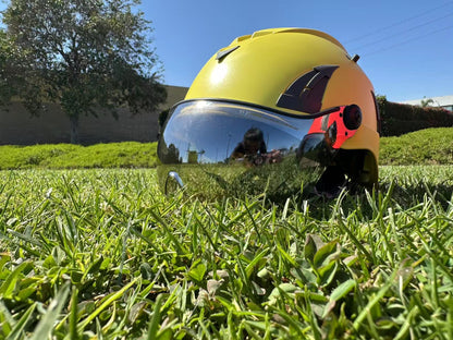 Low angle of yellow AeroPro Safety Helmets with Smoke Visor Kit on Grass. ANSI/ISEA Z89.1-2014 Type 1 Class C Safety Helmet with Smoke Visor used for Construction, Rescue & Arborist. 