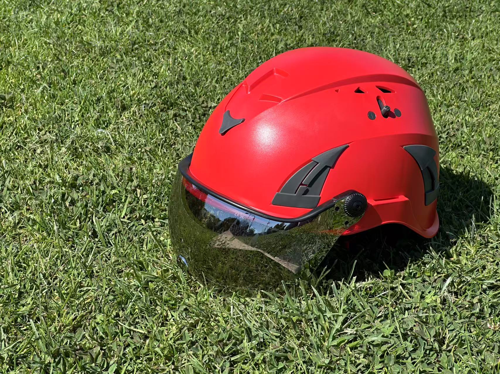 Low angle top down side view of red AeroPro Safety Helmets with Smoke Visor Kit. ANSI/ISEA Z89.1-2014 Type 1 Class C Safety Helmets with Smoke Visor used for Construction, Rescue & Arborist. 